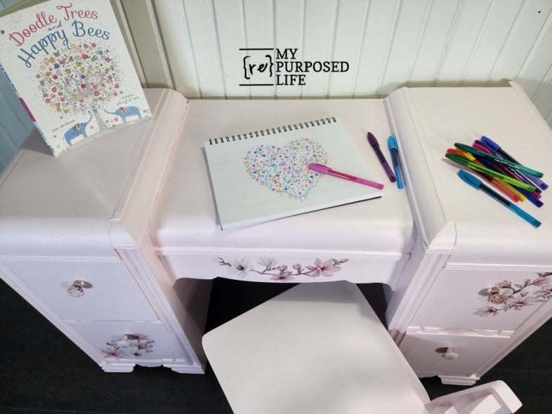 top of peony pink desk with sketchpad and markers