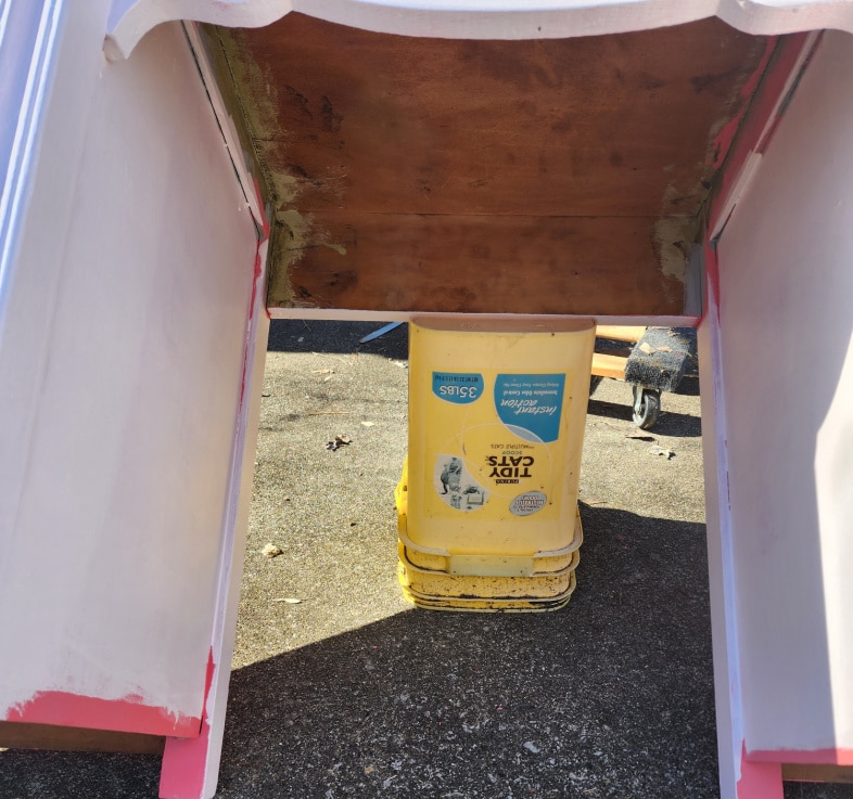 back of desk resting on a bucket to paint underside of desk