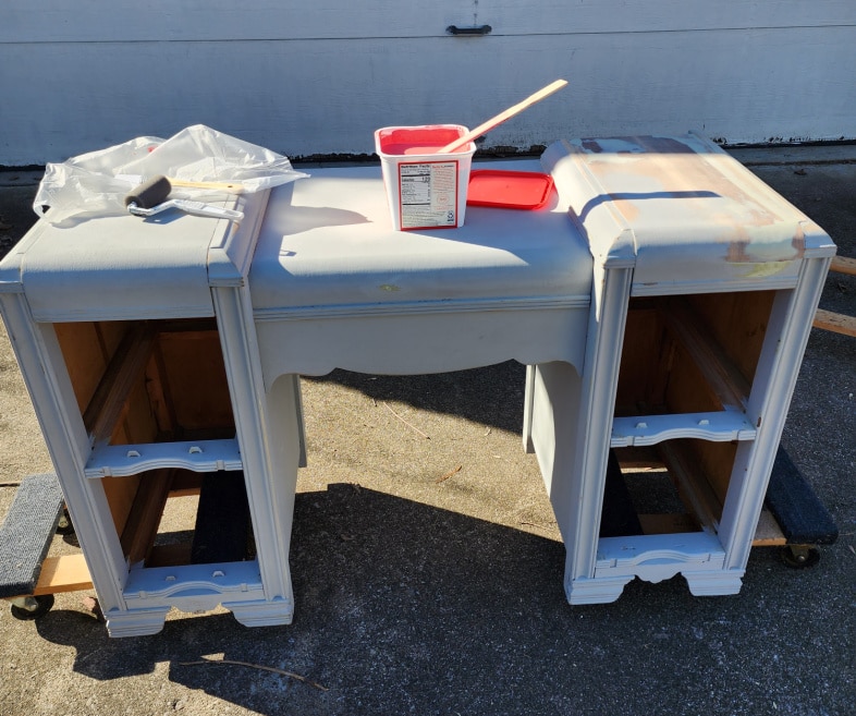 gray art deco vanity with paint supplies resting on the top