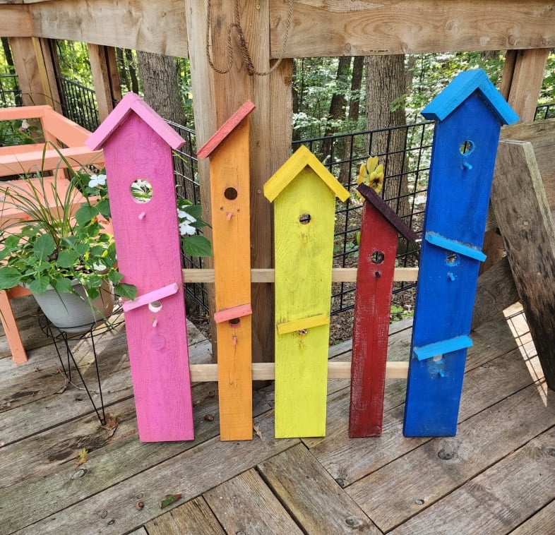 faux garden birdhouse garden decor standing upright on a deck