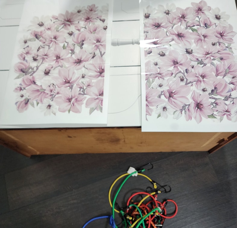 furniture transfer laying on a set of drawers, bungee cords laying on the floor
