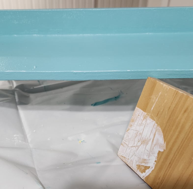 blue shelf with a hint of white paint showing on the edge