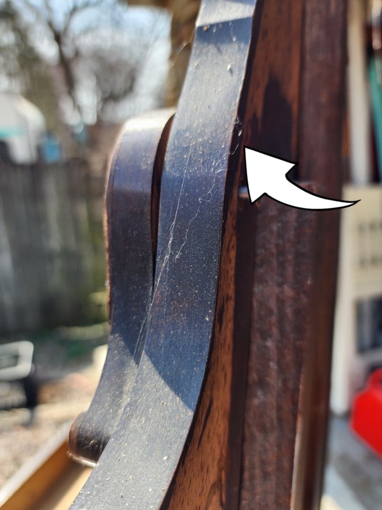 arrow pointing to the screw on the back of the mirror bracket