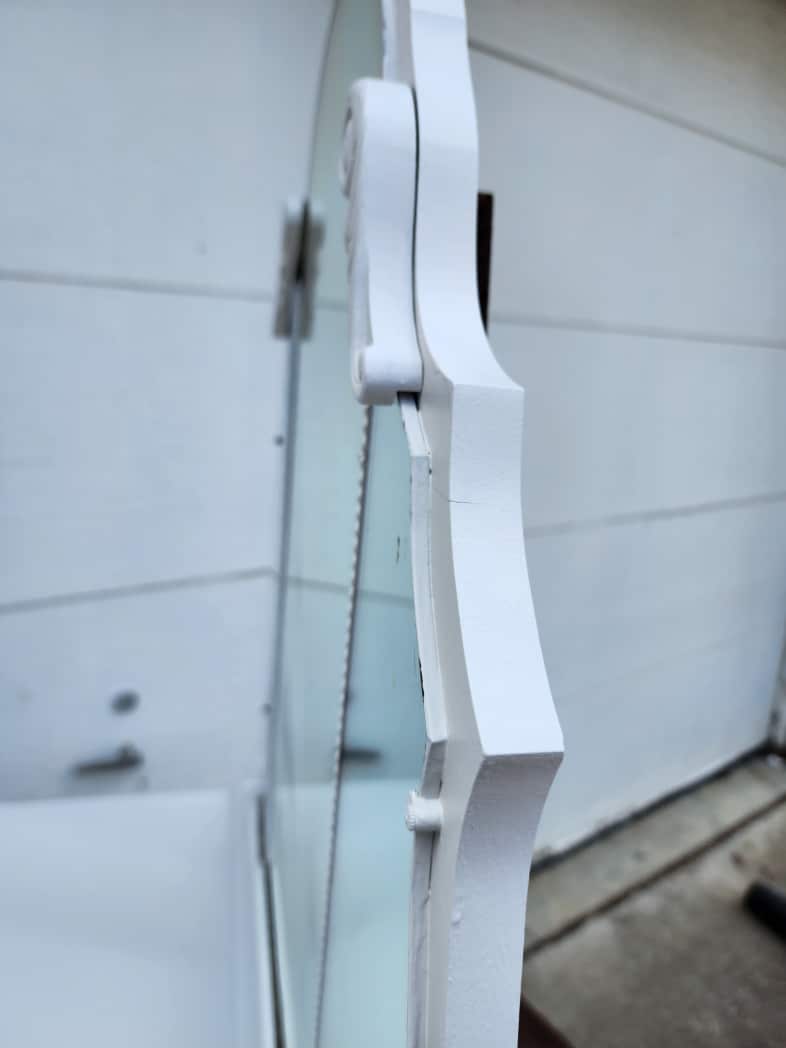 sideview revealing the edge of the old mirror is painted the same color as the antique dresser