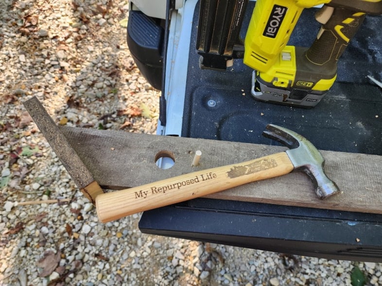 hammer resting on faux birdhouse board