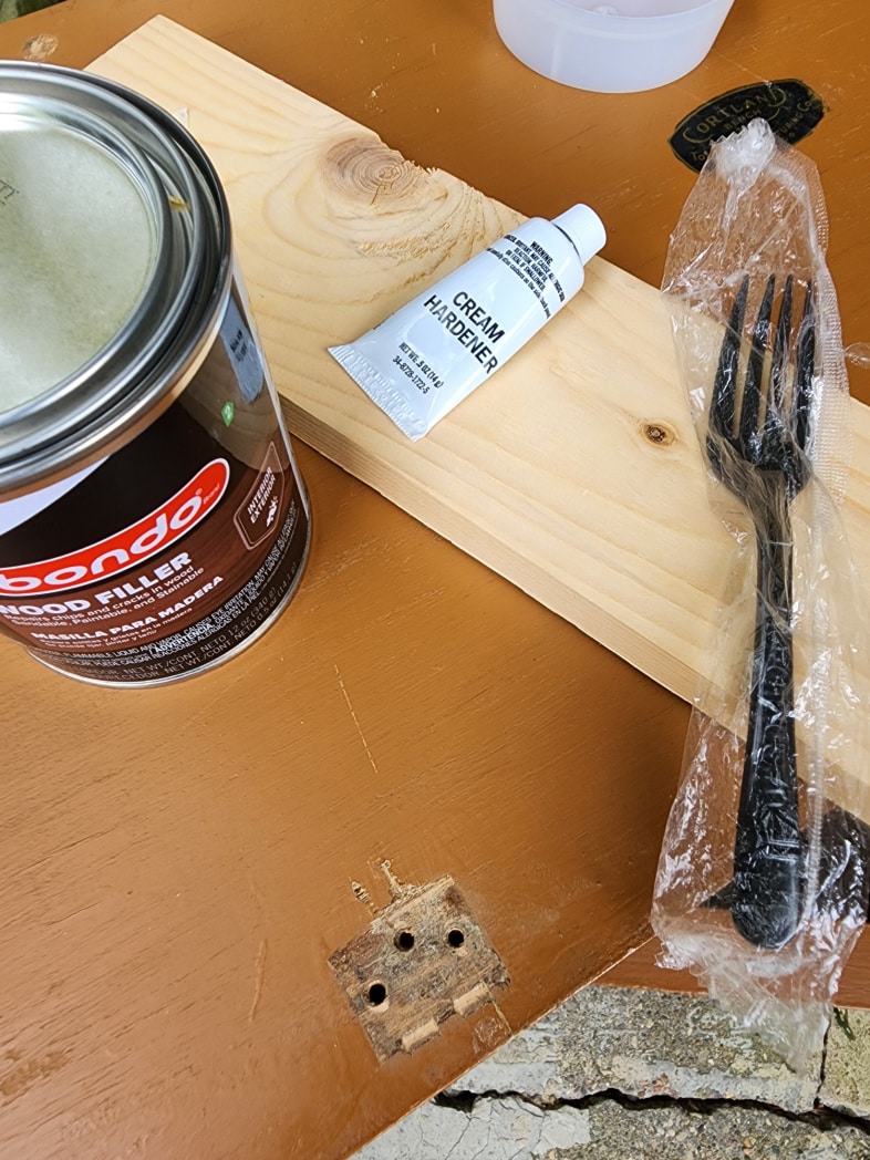 can of bondo, scrap wood, plastic fork