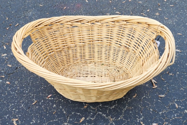 large wicker laundry basket sitting in the driveway