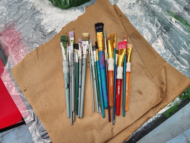 paintbrushes laying on brown paper