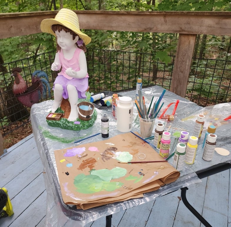 glass patio table with a statue paint and brushes