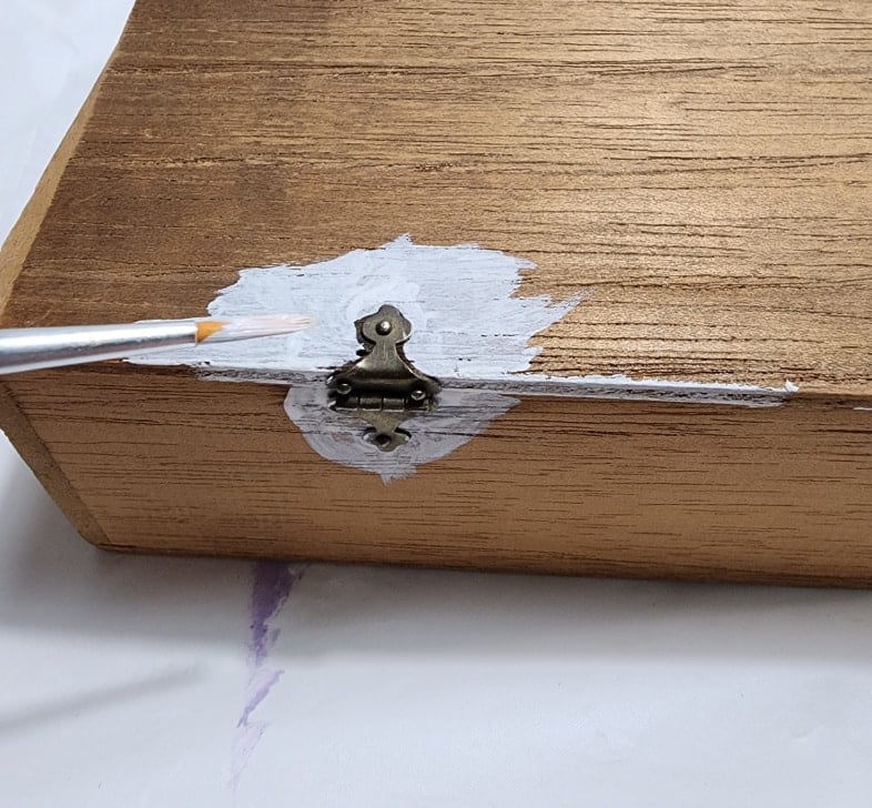 painting around small vintage hinges with an artist's paint brush
