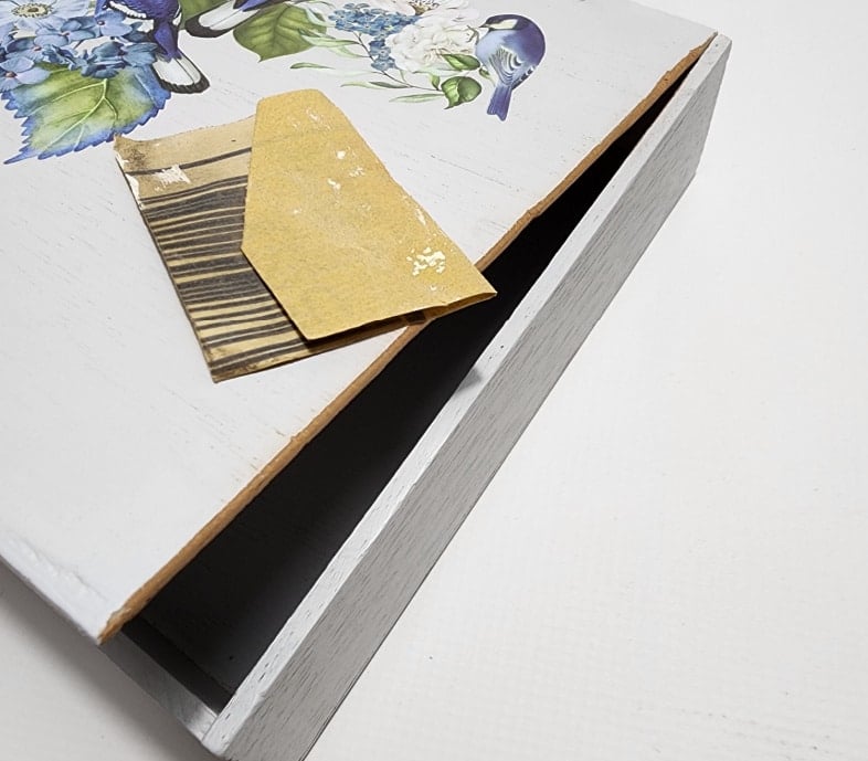 sandpaper on top of wooden box after sanding edge smooth