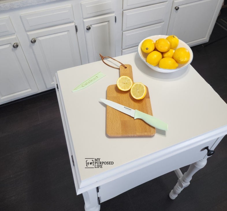 small kitchen island with wooden cutting board and lemons