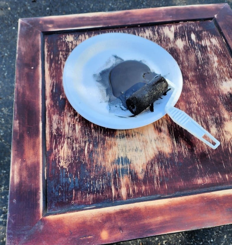 painting a tabletop with a small foam brush