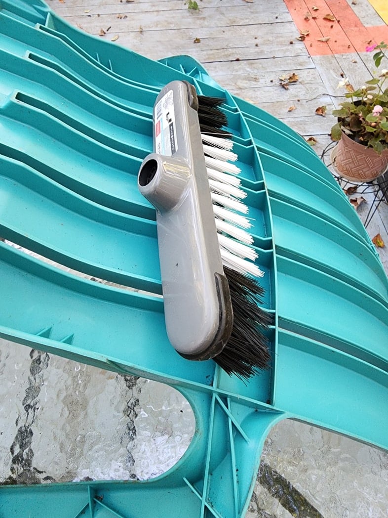 brushing debris from dirty plastic chairs