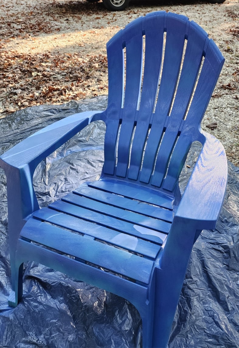 spray plastic chair upright with blue spray paint