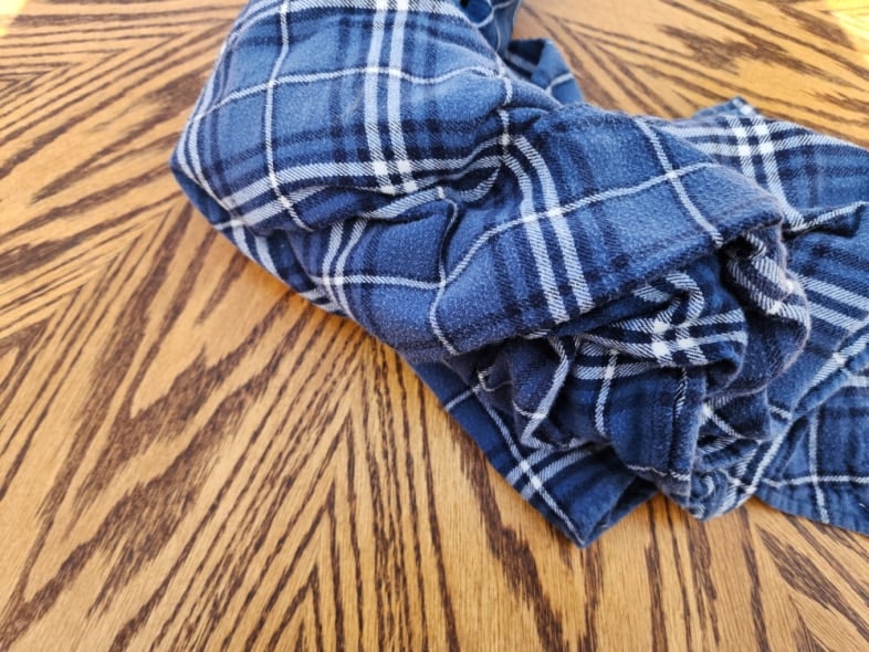 flannel shirt laying on oak kitchen table