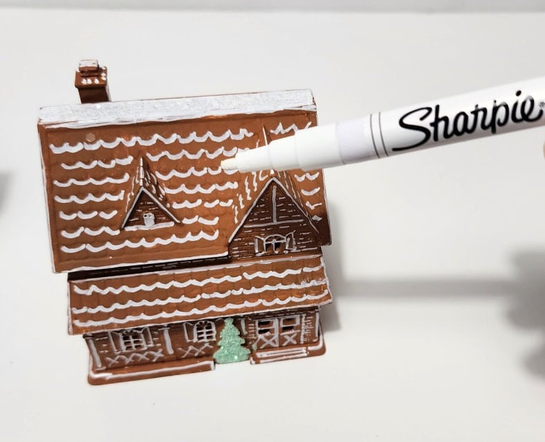 how to use a paint pen to decorate a gingerbread house
