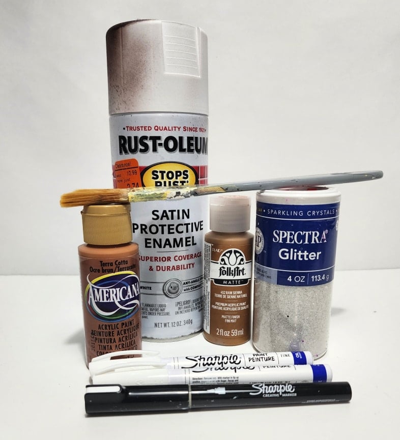 supplies for making a DIY gingerbread village out of a dollar store Christmas village