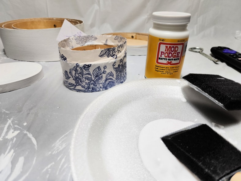 decoupage blue and white floral napkins onto wooden boxes