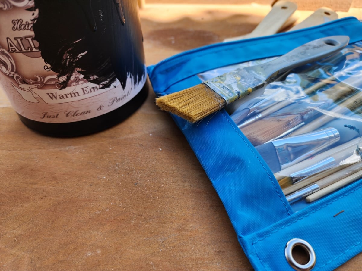 black paint and an assortment of paintbrushes