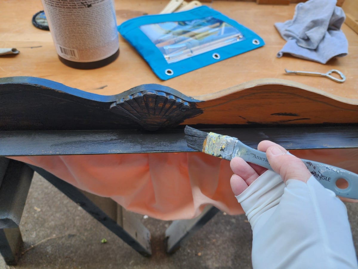 painting a coffee table black with a small paintbrush
