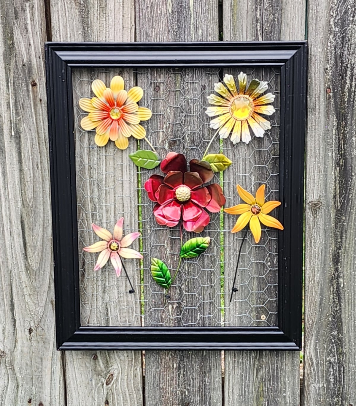 Dollar Tree metal flower craft hanging on a fence
