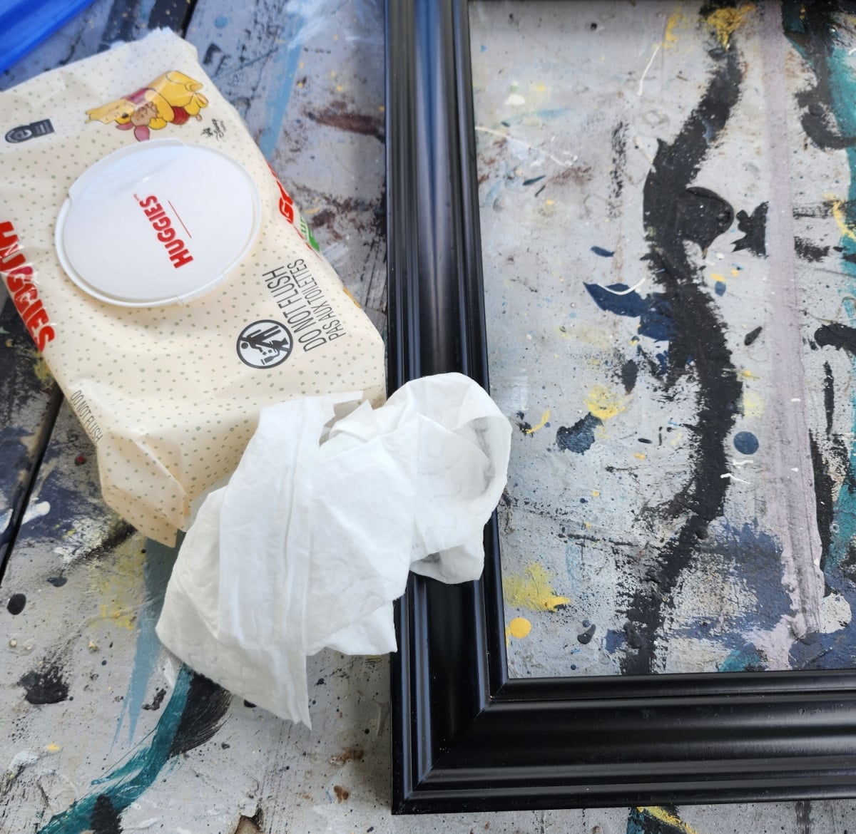 cleaning a wooden frame with a baby wipe