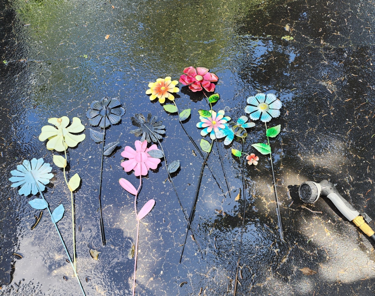 cleaning metal garden flowers with a hose