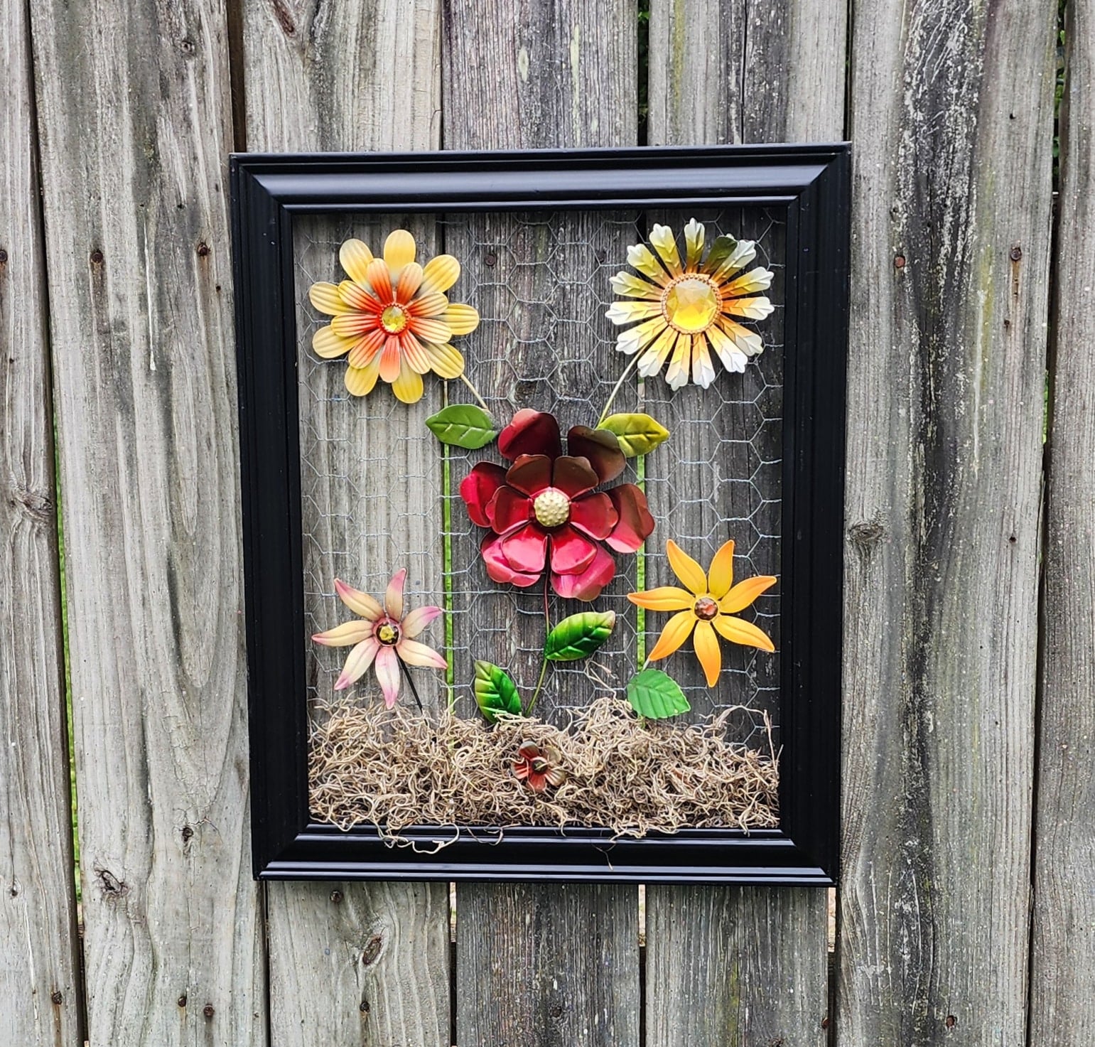 dollar store flower wall art hanging on a rustic fence