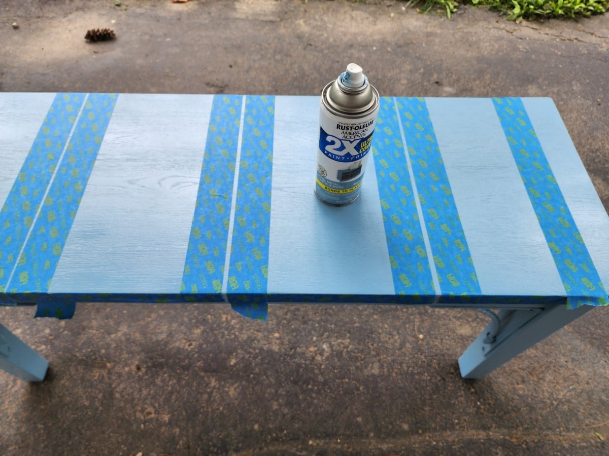 french blue spray paint on seat of bench