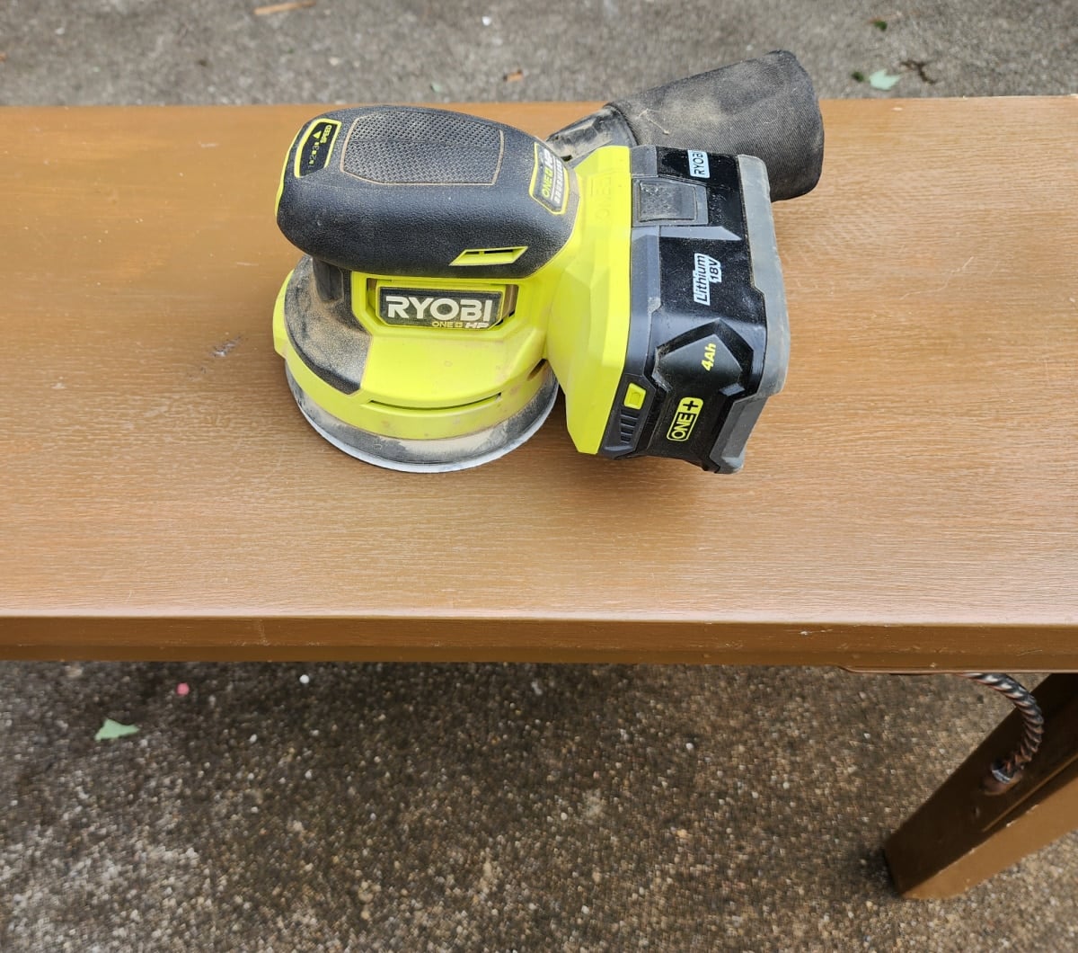 orbital sander on brown thrift store bench
