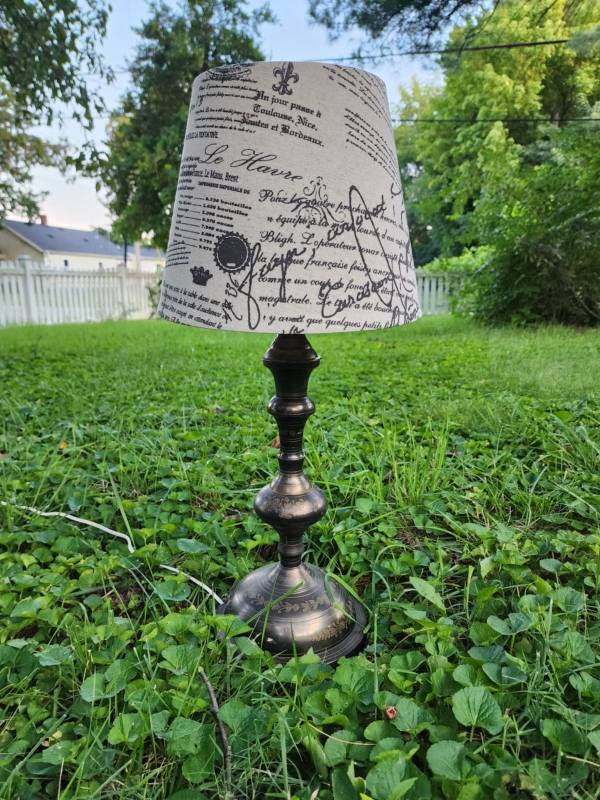 repurposed floor lamp into a table lamp sitting on the lawn