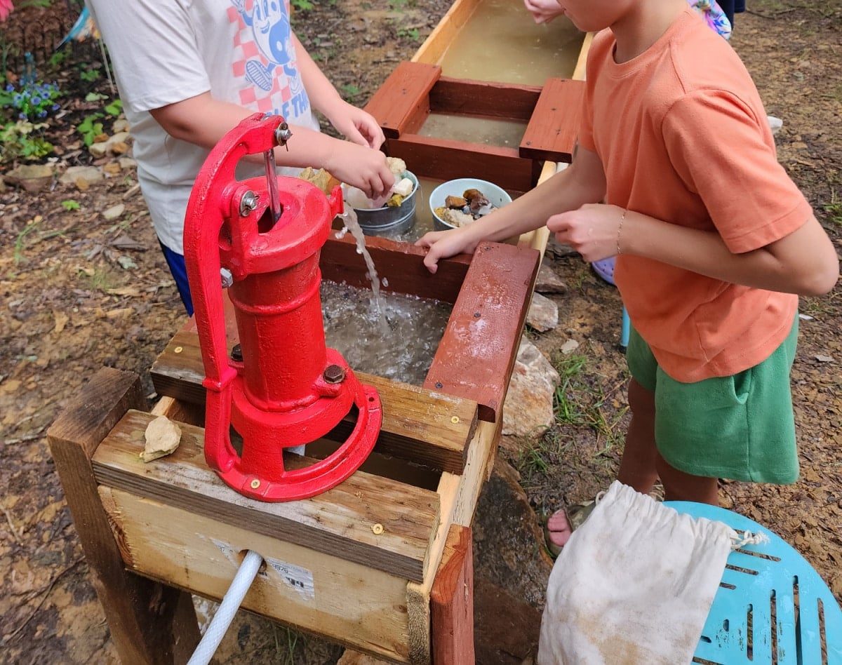 boys washing gems and rocks