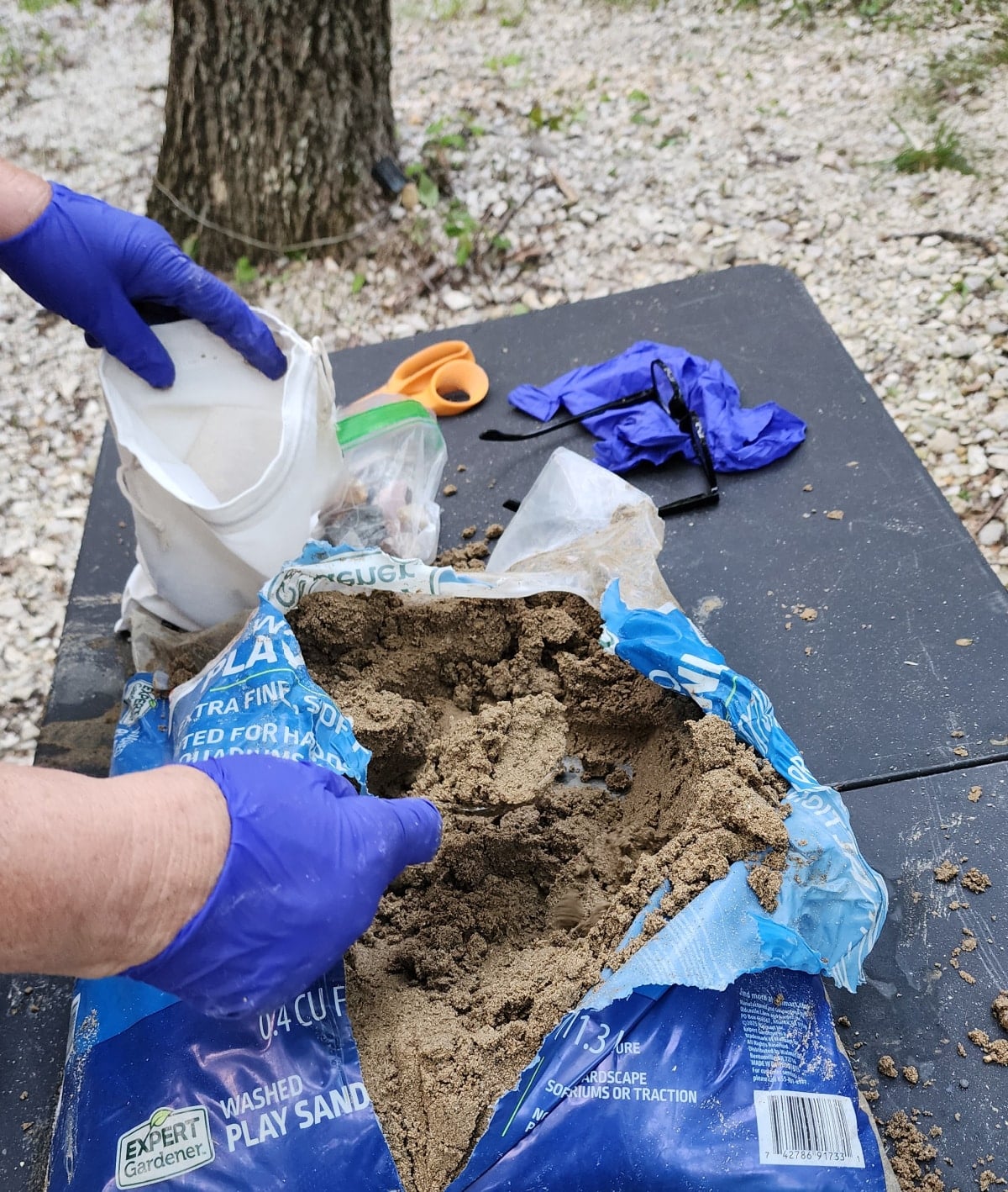filling canvas bag with sand and gems