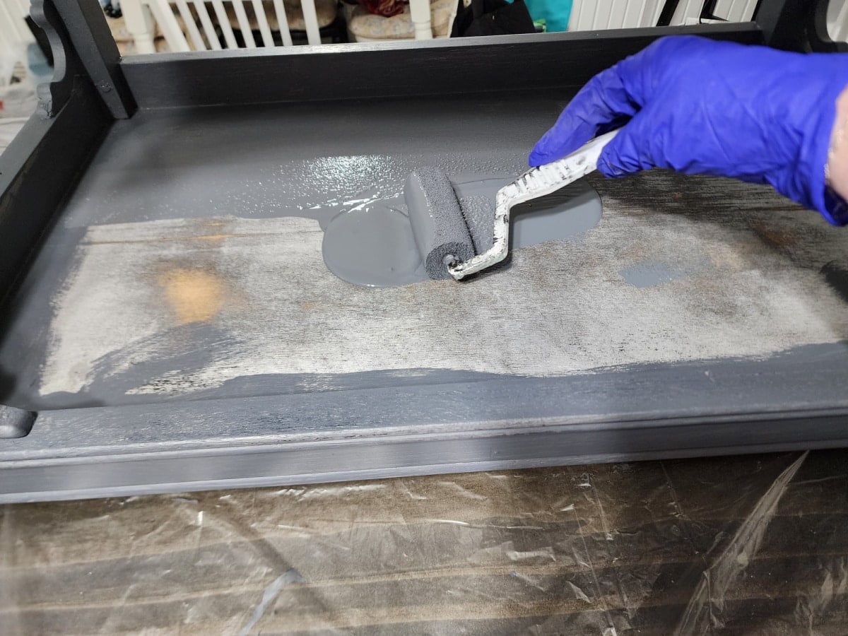 painting flat surfaces of a small table using a paint roller