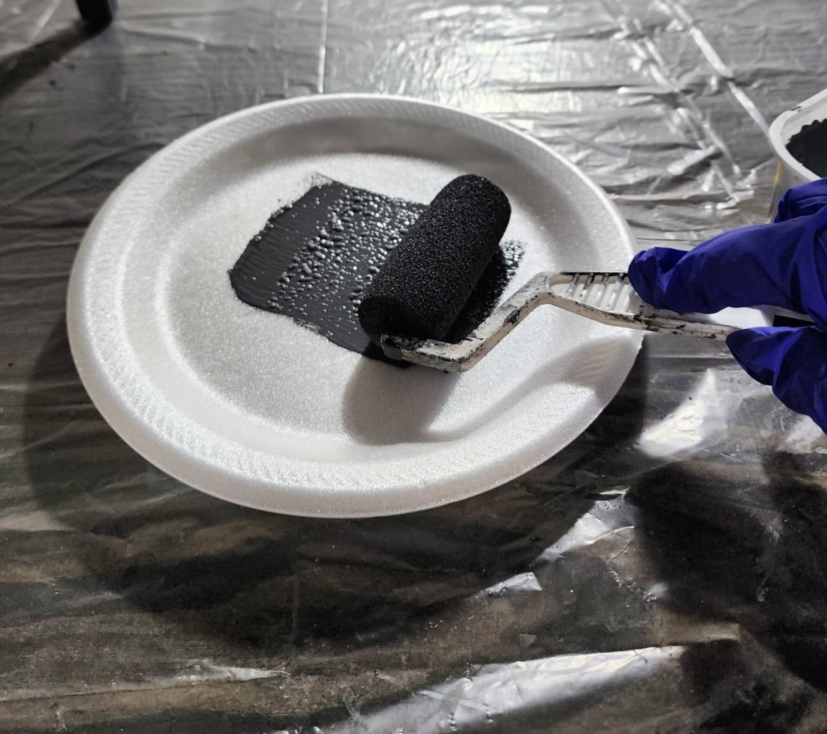 rolling off excess paint onto a styrofoam plate