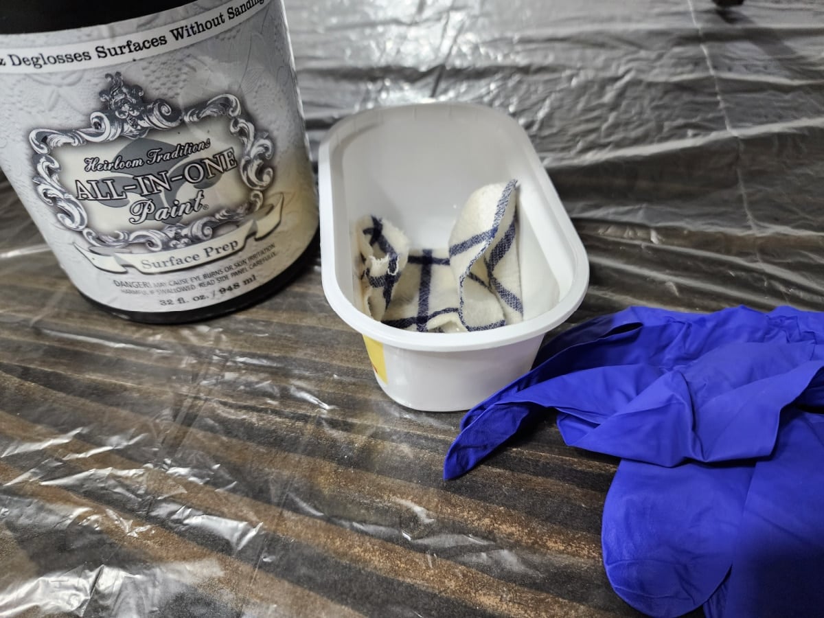 surface prep in a container with a rag and gloves